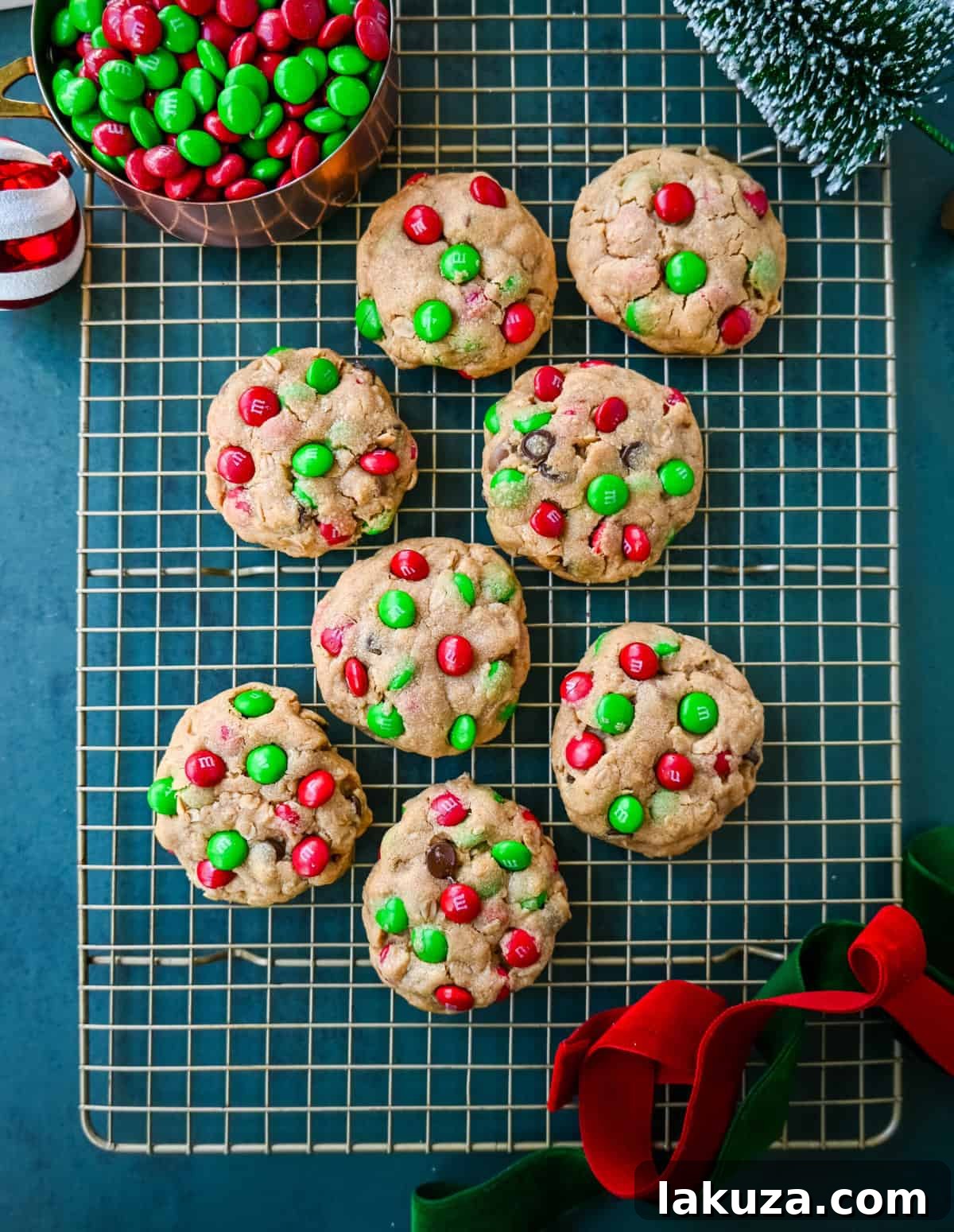 A tray of unbaked Christmas Monster Cookie dough balls, perfectly shaped and spaced evenly on a parchment-lined baking sheet, ready for the oven to create golden-brown treats.
