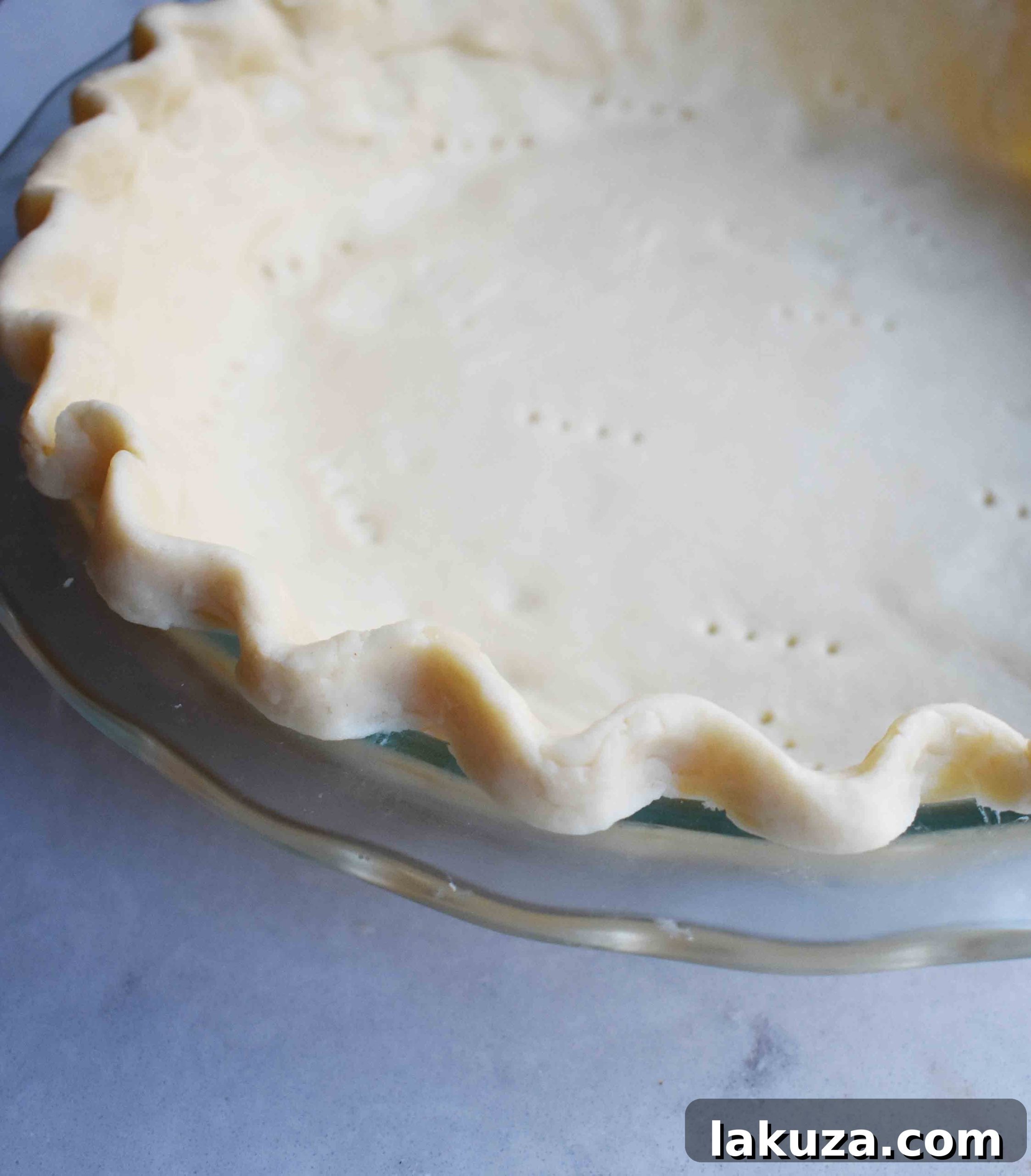 Pie crust lined with parchment paper and filled with pie weights for blind baking