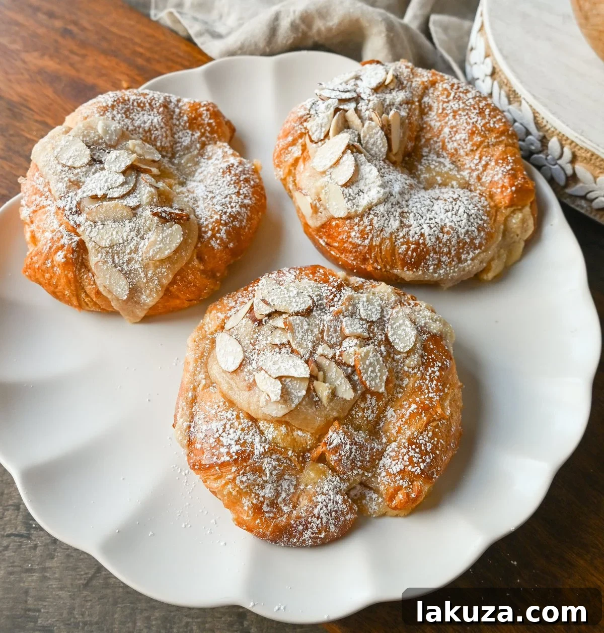 Easy homemade almond croissants with a golden-brown crust and powdered sugar dusting, ready to be enjoyed with coffee.