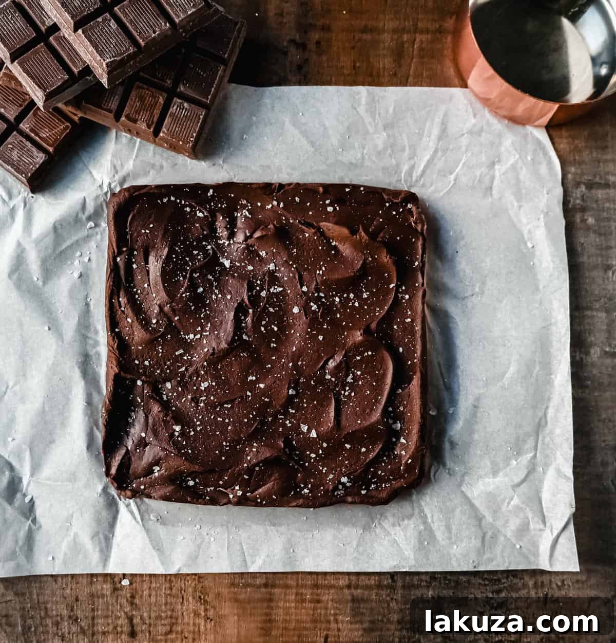 A perfectly cut square of Easy 2-Ingredient Microwave Chocolate Fudge, showcasing its rich brown color and smooth edges, inviting a bite.