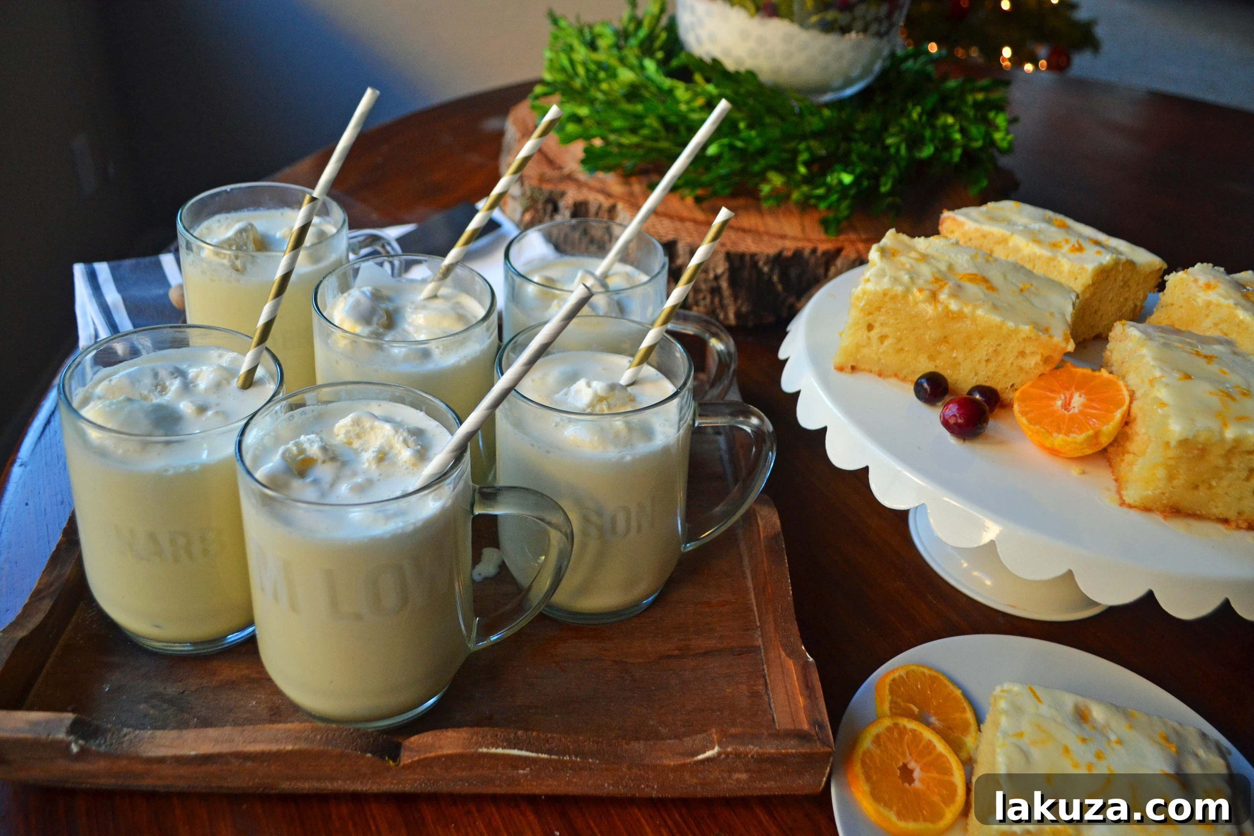 A festive holiday breakfast table featuring Orange Roll Breakfast Cake, fresh oranges, and a glass of Grandma's Famous Egg Nog.