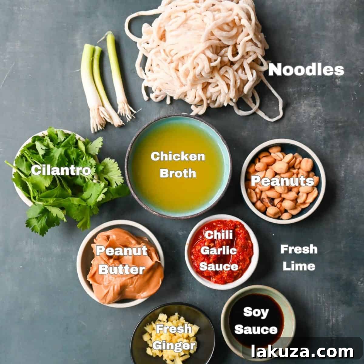 Creamy Chili Peanut Noodles 3 Close-up of fresh ingredients laid out for making Spicy Peanut Noodles, including peanut butter, soy sauce, ginger, chili garlic sauce, and lime.