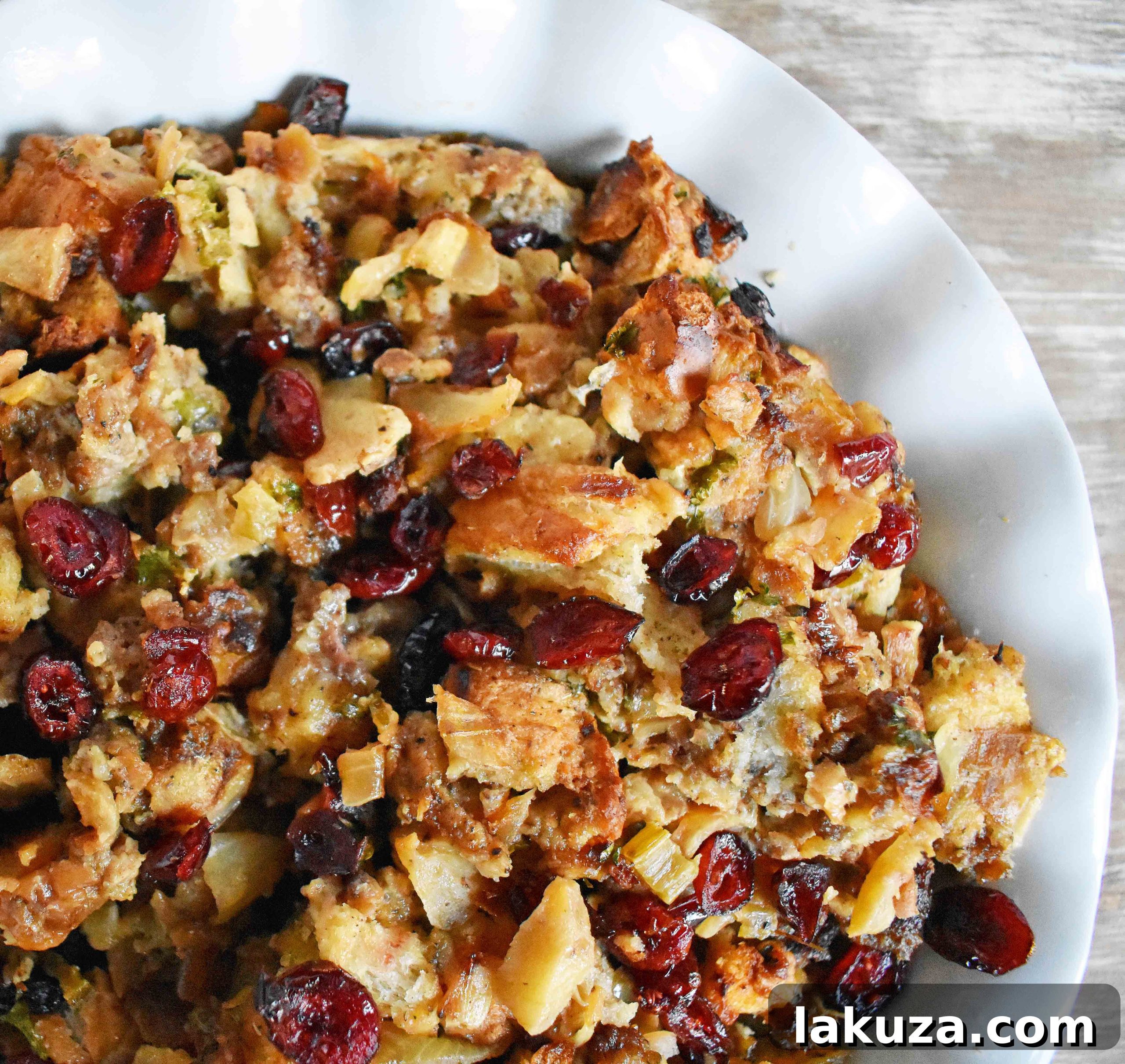A festive Thanksgiving table setting with a large serving of Cranberry Apple Sausage Stuffing as the centerpiece.