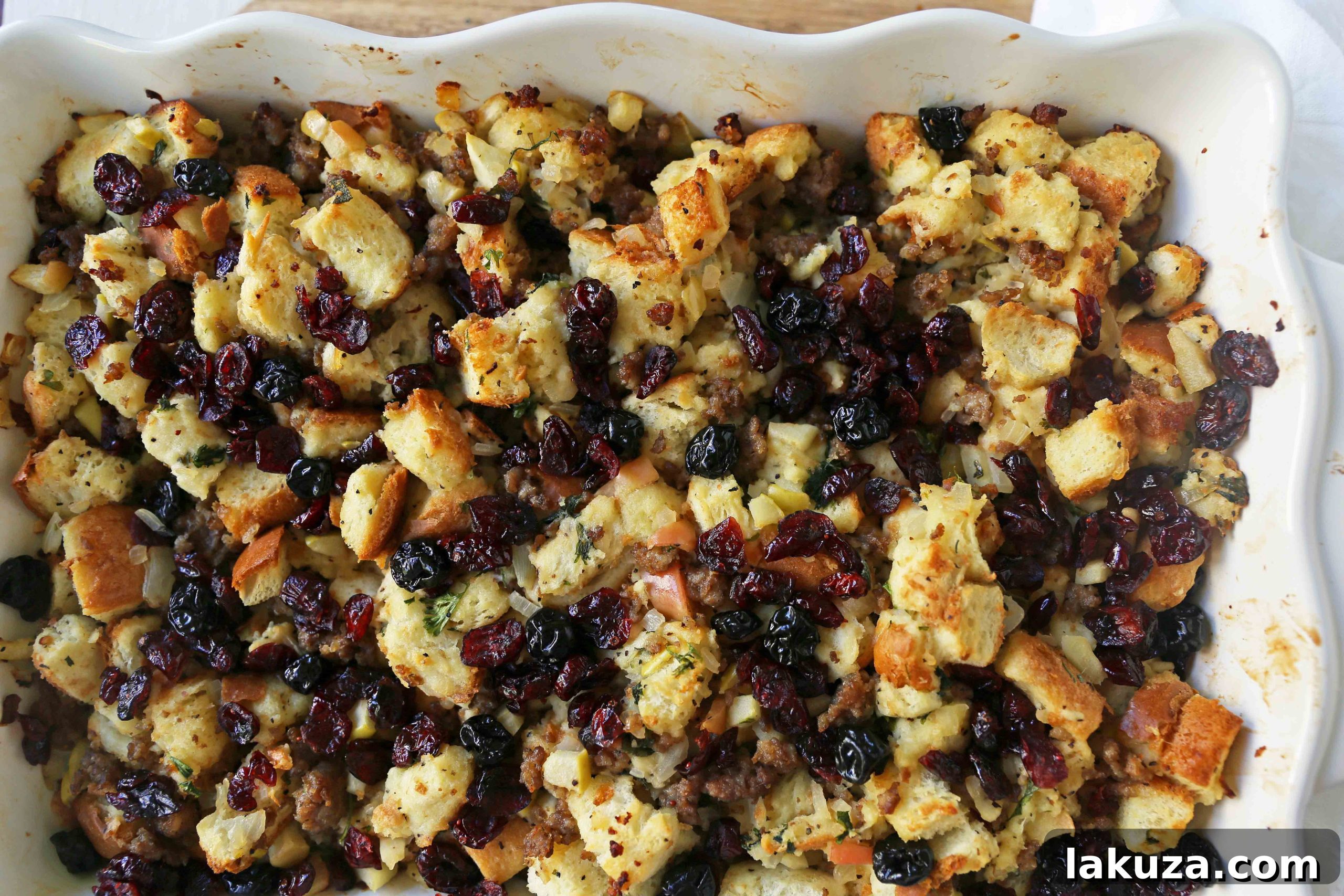 Serving dish filled with Cranberry Apple Sausage Stuffing, ready for a Thanksgiving dinner.