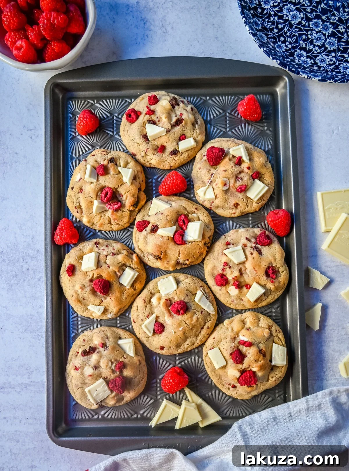 Close-up of a stack of fluffy white chocolate raspberry cookies, showcasing their soft texture and generous inclusions of fruit and chocolate.
