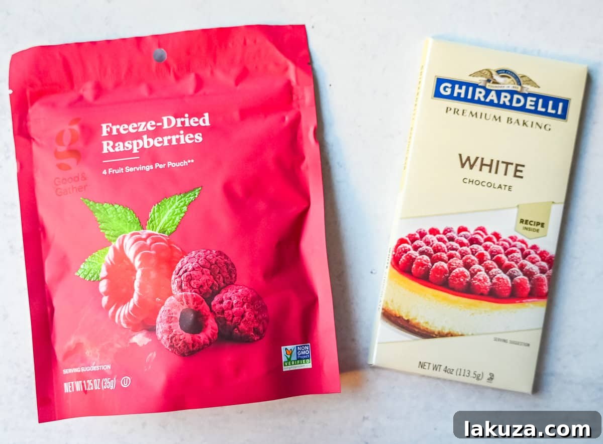 A bowl of vivid freeze-dried raspberries mixed with white chocolate chips, highlighting the key ingredients.
