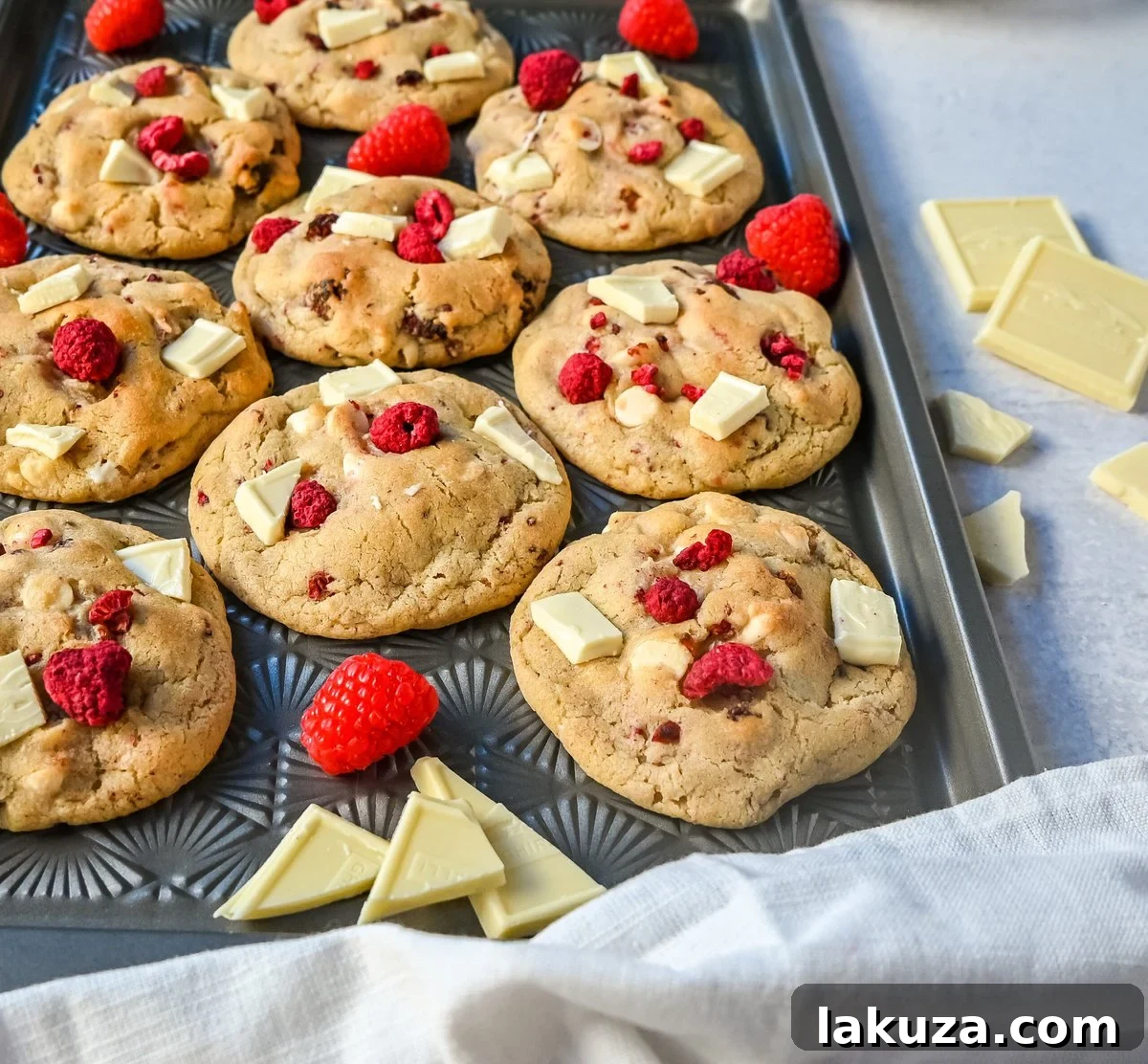 An array of delicious white chocolate raspberry cookies neatly arranged on a white platter, inviting guests to enjoy.
