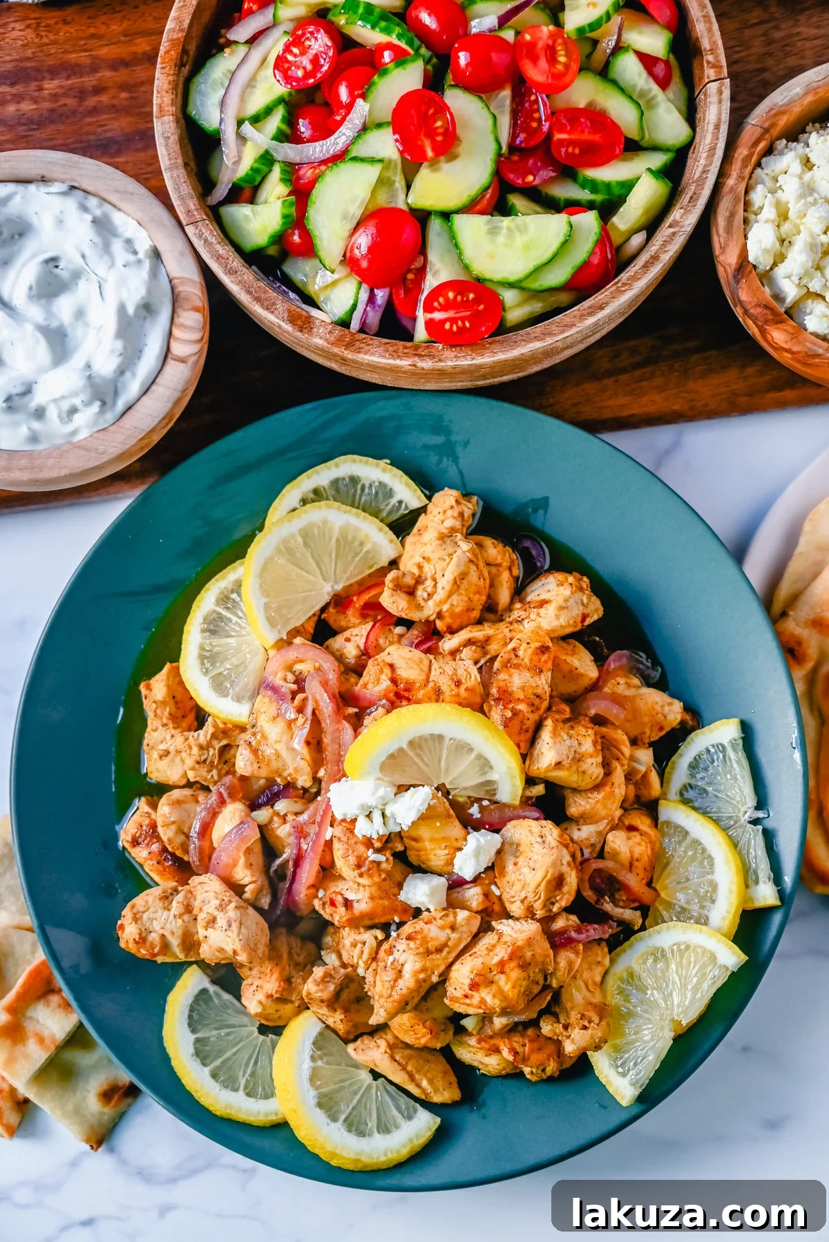 Grilled chicken shawarma skewers with lemon wedges and herbs.