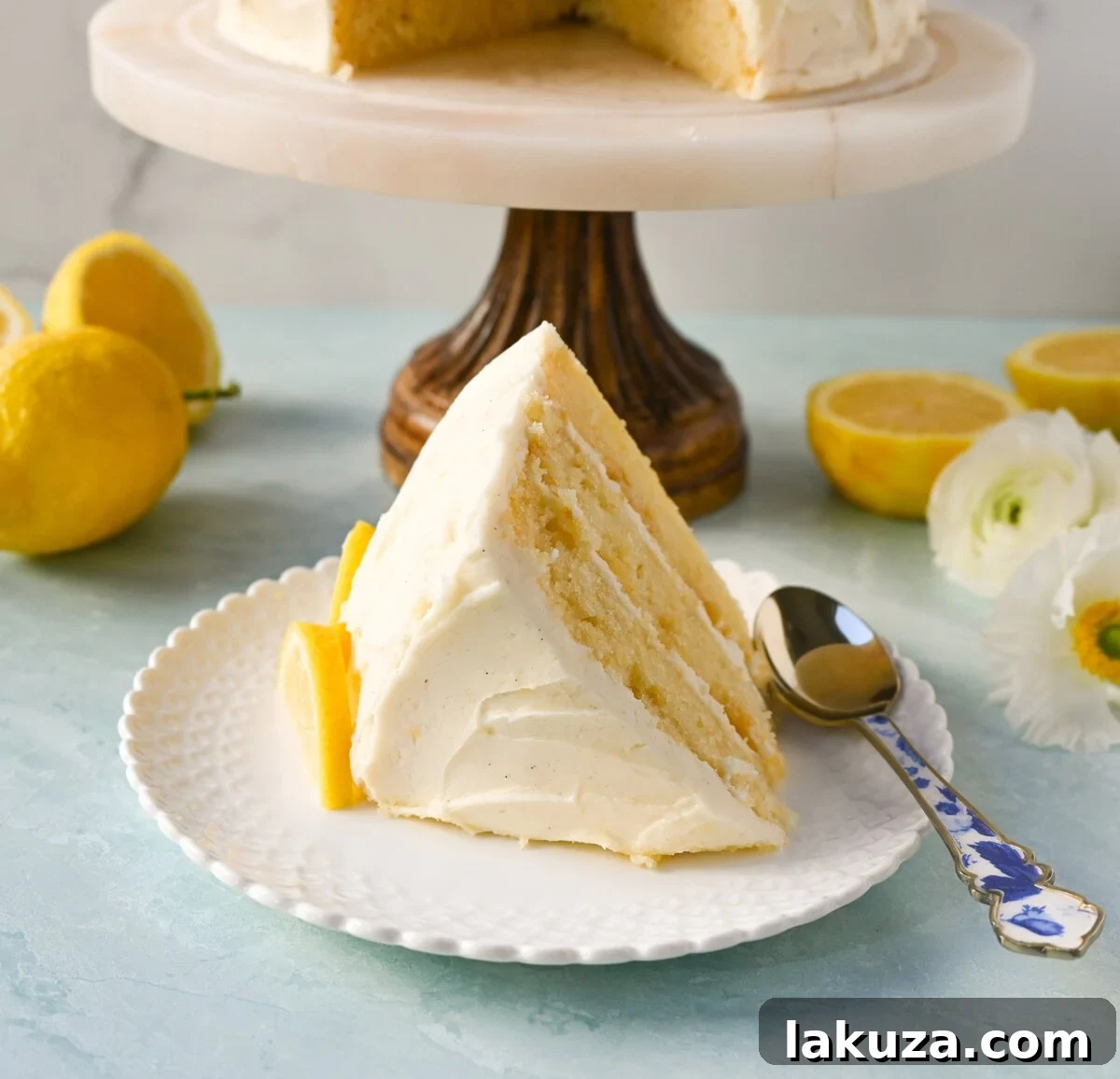 A beautifully garnished Best Lemon Cake Recipe, adorned with fresh lemon slices and berries on top of the creamy lemon frosting.