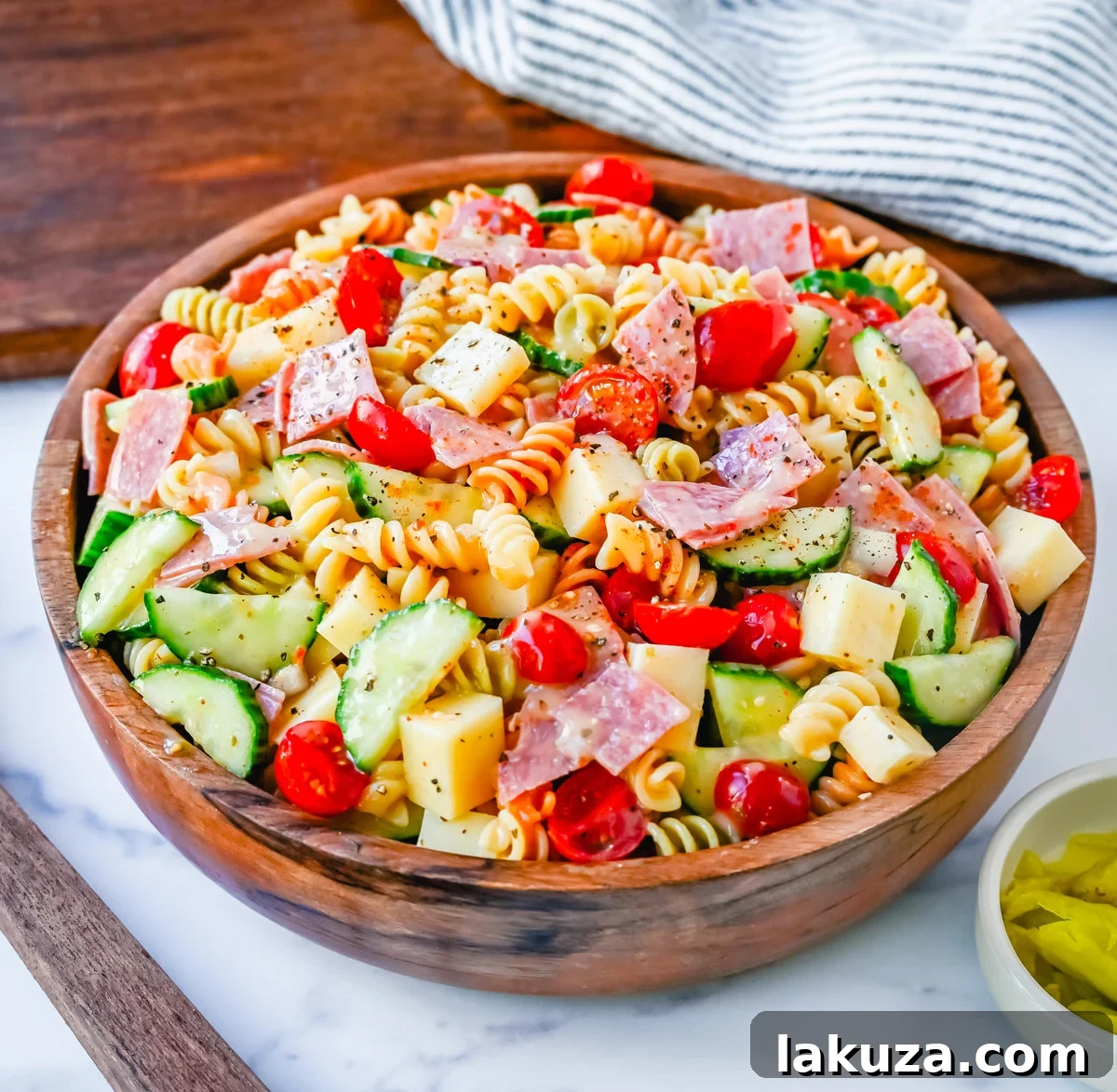A serving of Easy Pasta Salad in a bowl, showcasing the perfectly cooked pasta, colorful vegetables, cheese, and salami, ready to be enjoyed as a side dish or light meal.