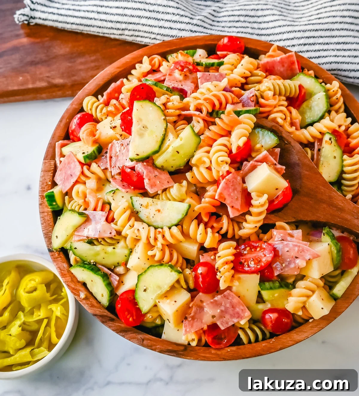 A large bowl of Easy Pasta Salad, glistening with dressing and filled with a colorful array of ingredients, ready for a potluck or family meal.