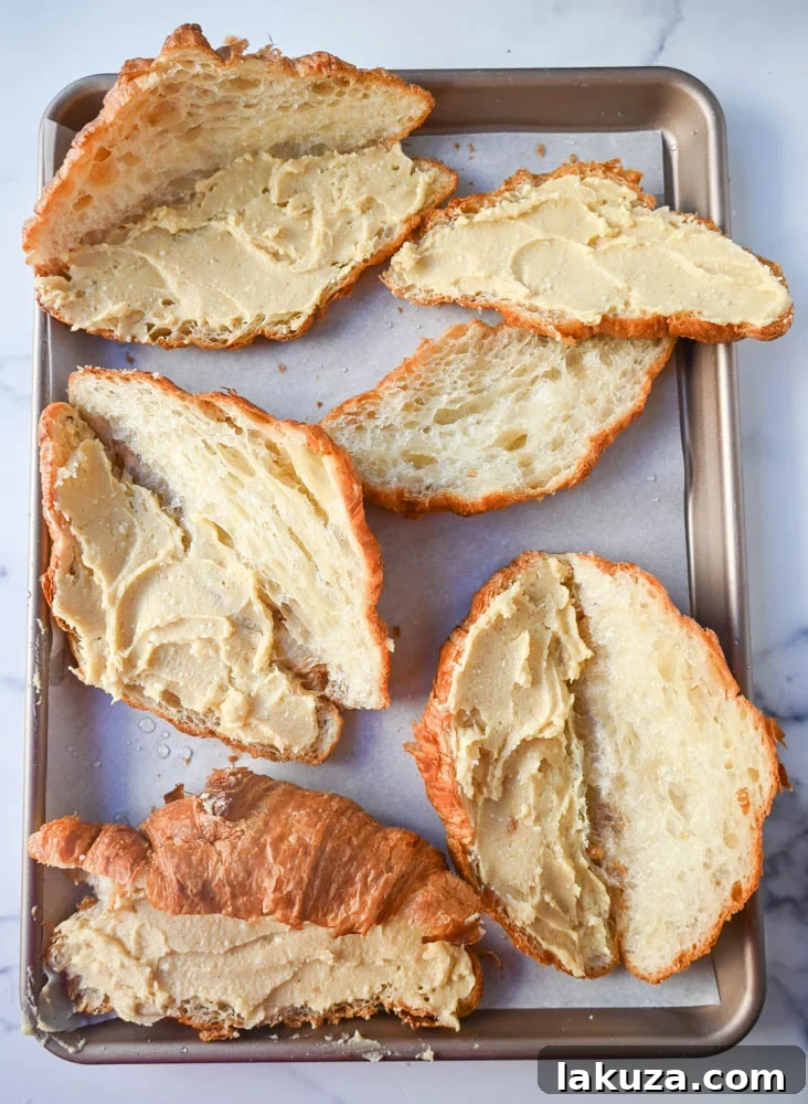 Irresistible Chocolate Almond Croissants 5 Spreading homemade almond frangipane generously onto a croissant half.