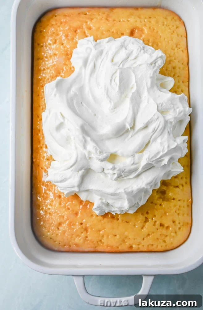 A bottle of Cream of Coconut, a key ingredient for the Coconut Poke Cake, on a kitchen counter.
