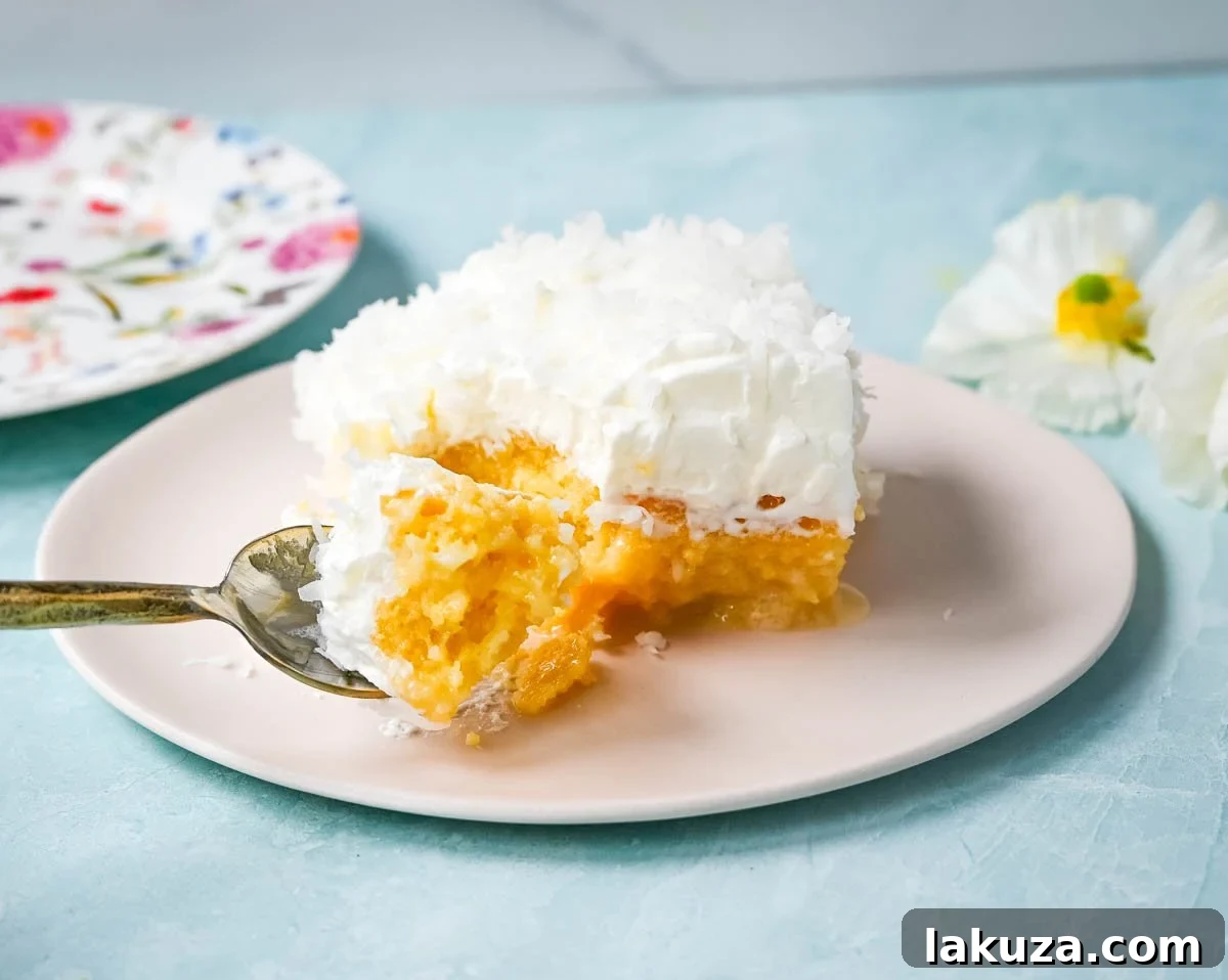 A beautifully presented Coconut Poke Cake, perfectly sliced and ready to be served at a gathering.