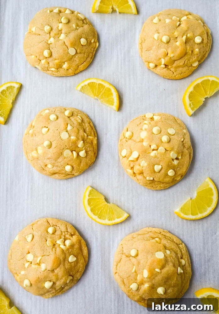 A single, perfectly baked Levain Bakery Lemon Cookie, torn open to reveal its soft, thick, and gooey interior with visible lemon chips.