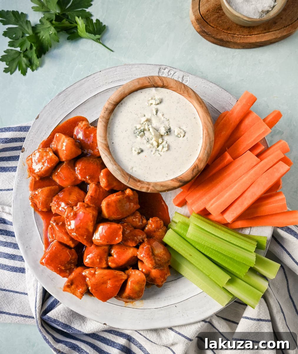 Seasoned raw chicken breast pieces ready for cooking in a skillet, showcasing the pre-sauce flavor infusion for Buffalo Chicken Bites.
