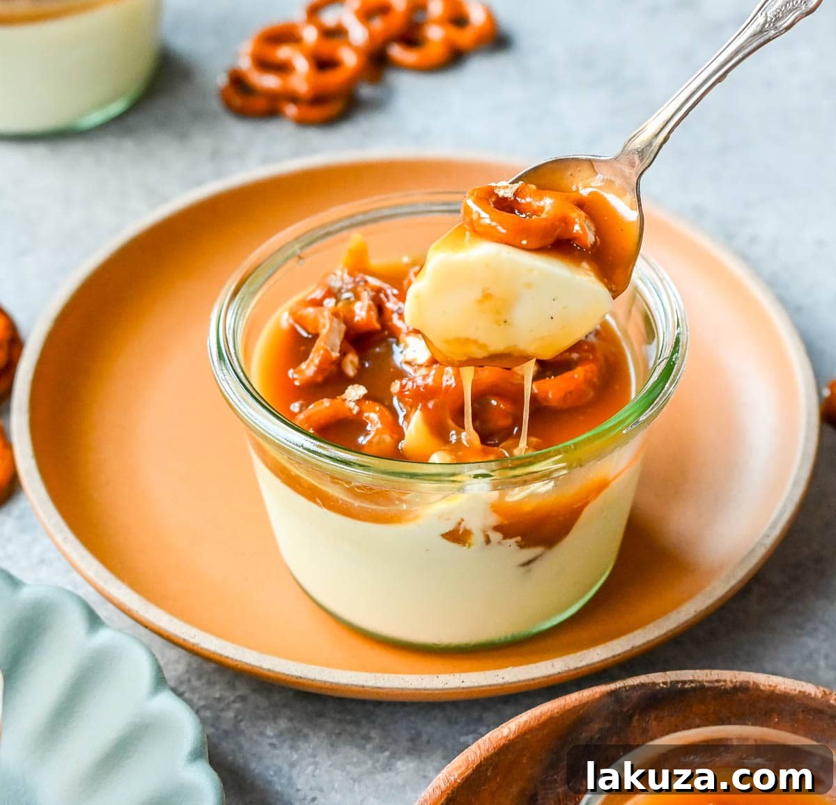 Plates of panna cotta, each adorned with a generous drizzle of homemade salted caramel and a scattering of crispy, golden butter toffee pretzels.