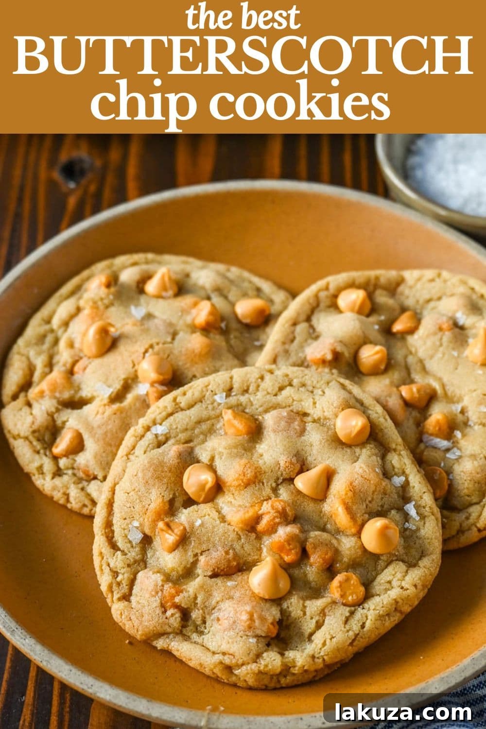 A large batch of butterscotch chip cookies on a baking sheet, featuring visible butterscotch chips and a golden-brown finish.