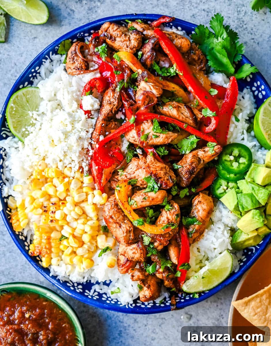 Sizzling Chicken Fajita Bowl 4 Close-up of a Chicken Fajita Bowl showcasing a variety of fresh and flavorful toppings, including guacamole and salsa.