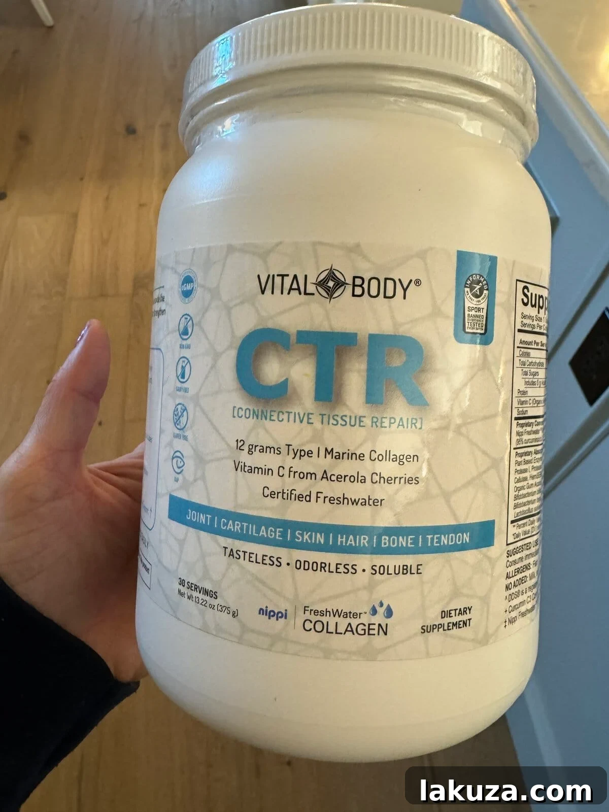 A container of marine collagen powder, possibly next to a smoothie or protein shake, highlighting a healthy supplement.