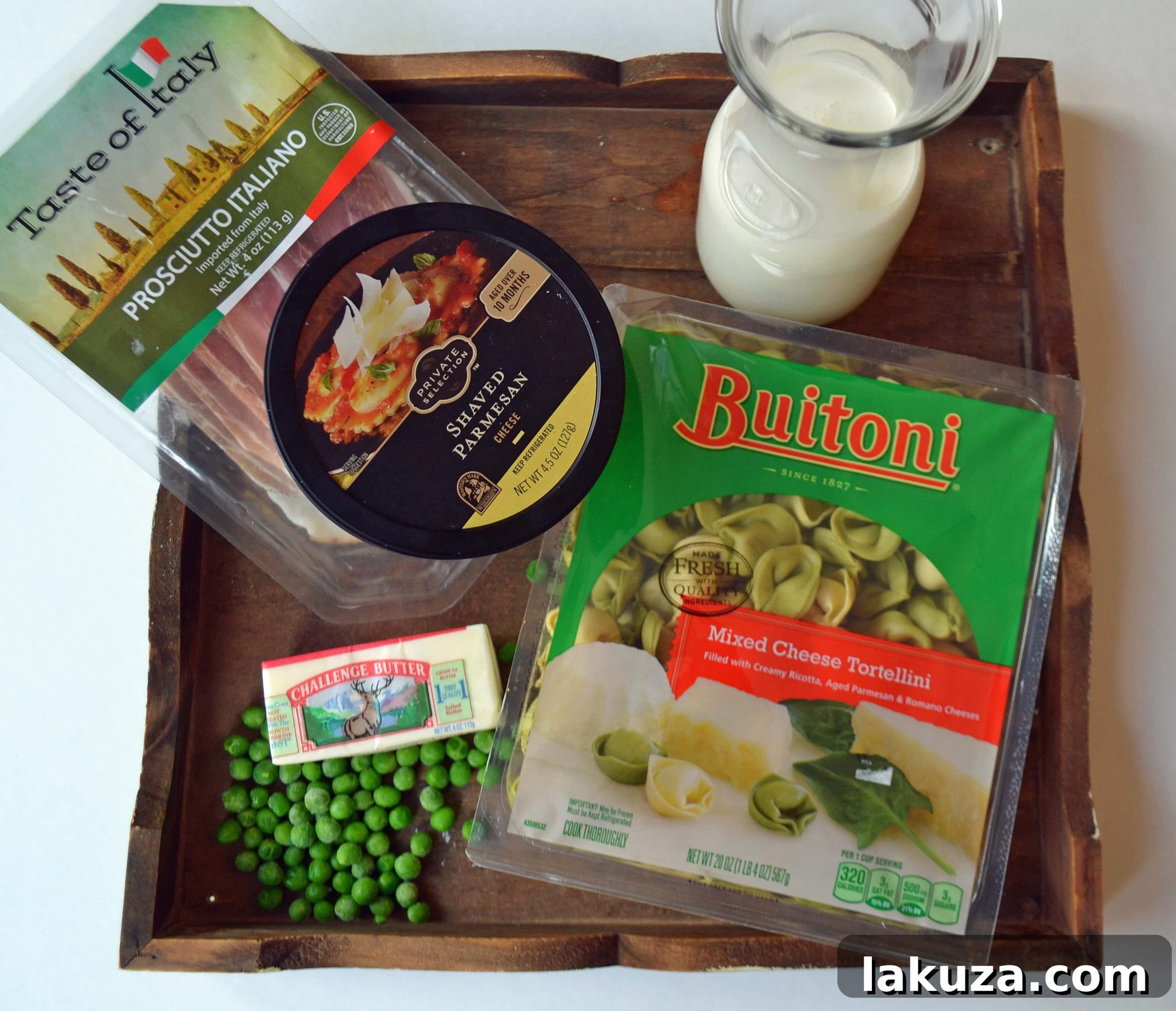 A serving of Creamy Tortellini with Prosciutto and Peas in a white bowl, garnished with fresh basil.