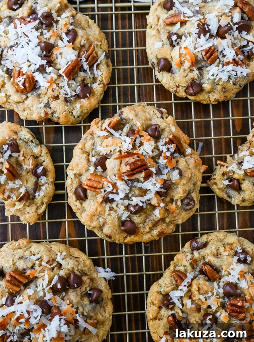 A close-up of a batch of freshly baked Cowboy Cookies, showing their rich texture and generous mix-ins.