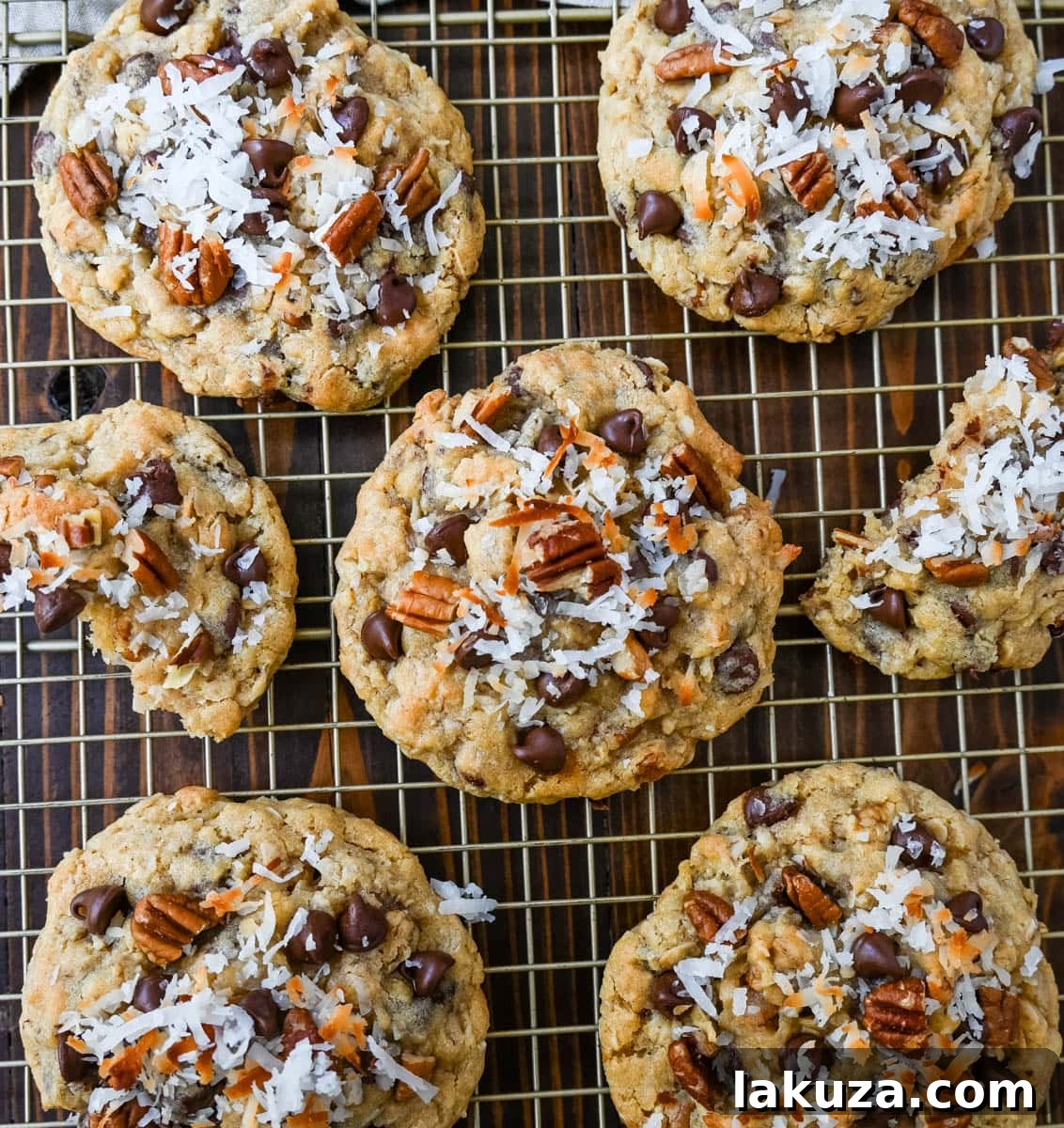 A tray of freshly baked Cowboy Cookies, cooling on parchment paper.