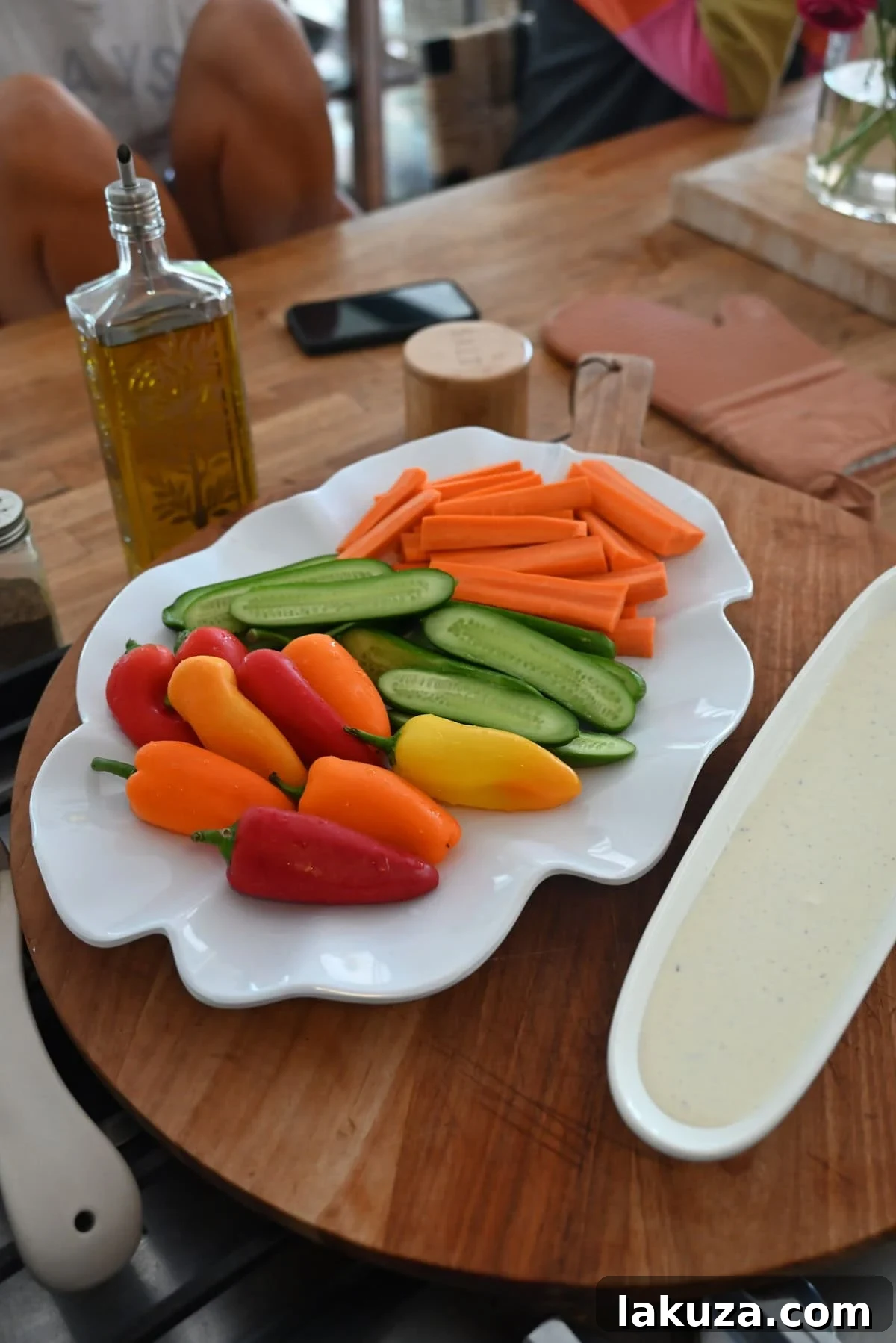 A colorful plate featuring fresh fruit and vegetables with a dipping sauce