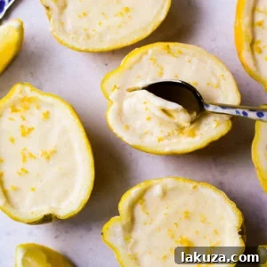 A top-down view of a small bowl of lemon posset with a spoon, ready to be enjoyed.