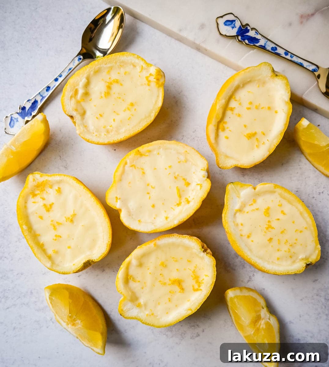 Fresh, bright yellow lemons and a small glass bowl of finely grated lemon zest, ready for a dessert recipe.