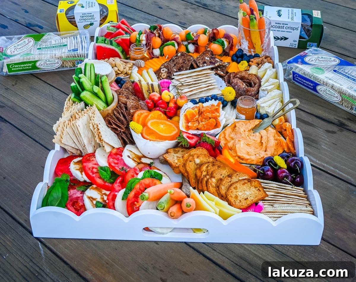A vibrant and beautifully arranged charcuterie board showcasing a variety of summer delights, garnished with edible flowers.
