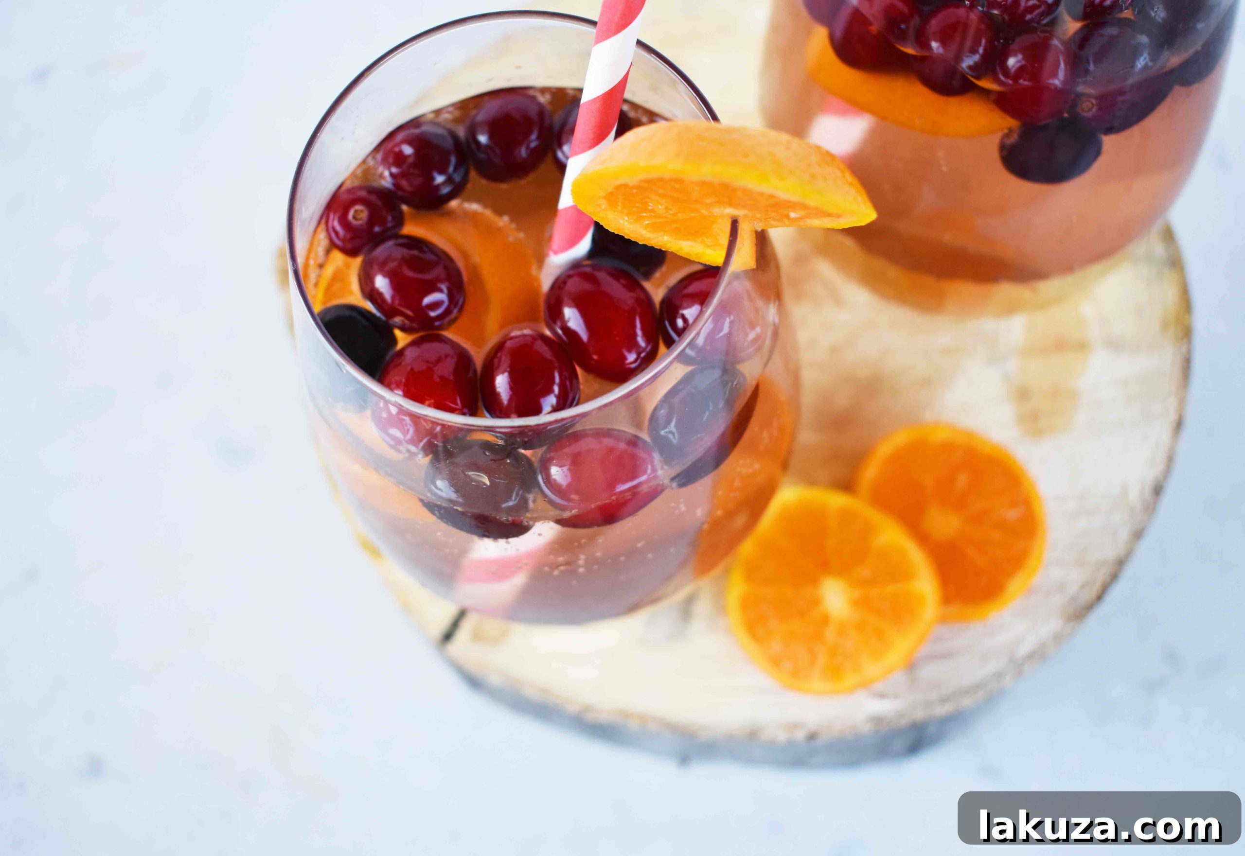 The Henry Crimson Citrus Sparkler 3 Close-up of The Henry Cranberry Orange Mocktail, showing fresh oranges and cranberries in a glass.