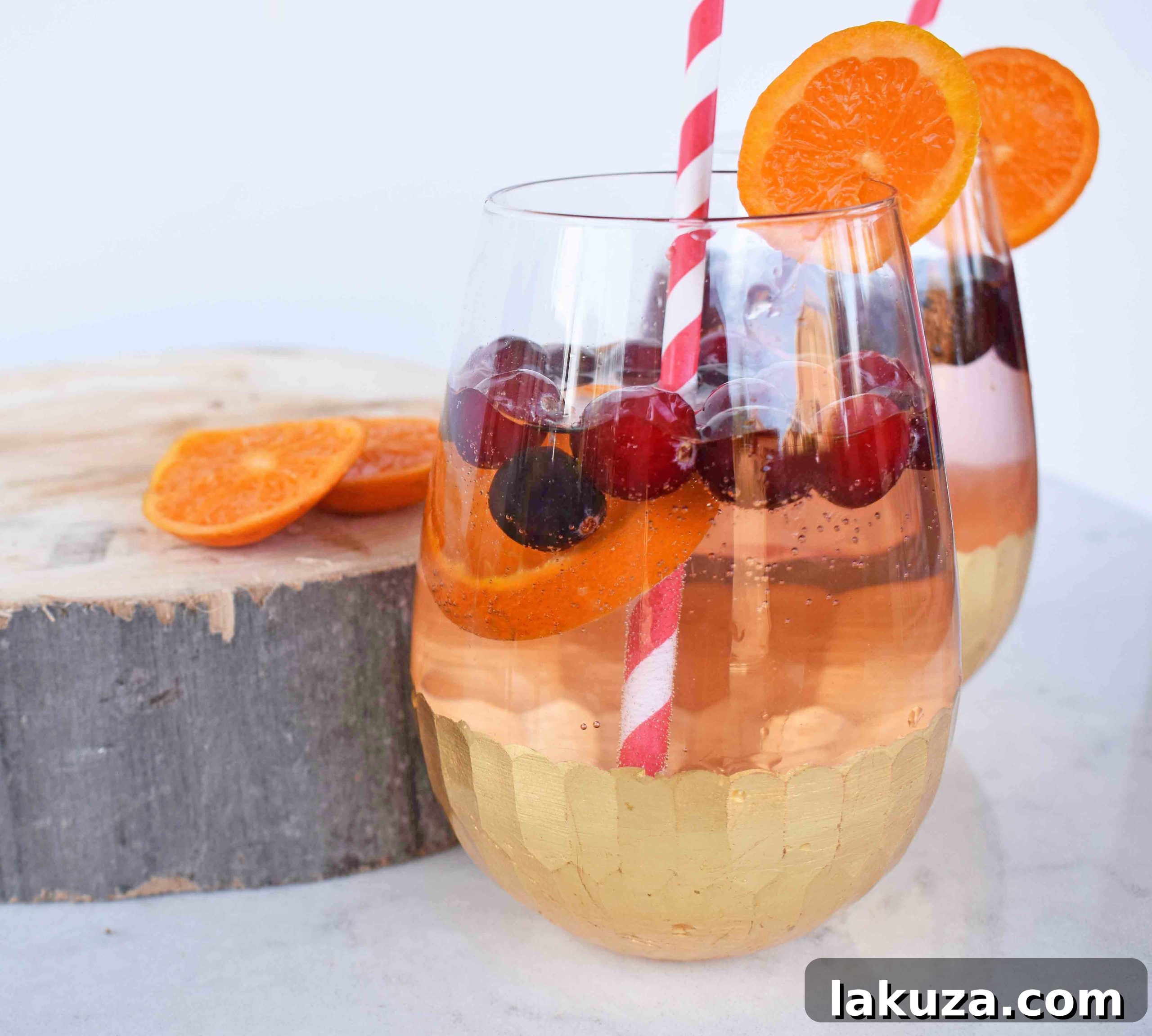 The Henry Crimson Citrus Sparkler 5 A festive glass of The Henry Cranberry Orange Mocktail with cranberries, orange slices, and mint.