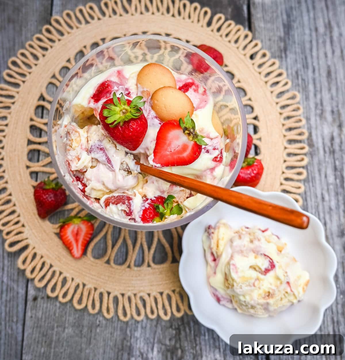 Overhead shot of Magnolia Bakery Strawberry Shortcake Pudding garnished with fresh strawberry slices and wafer crumbles in a large glass bowl.
