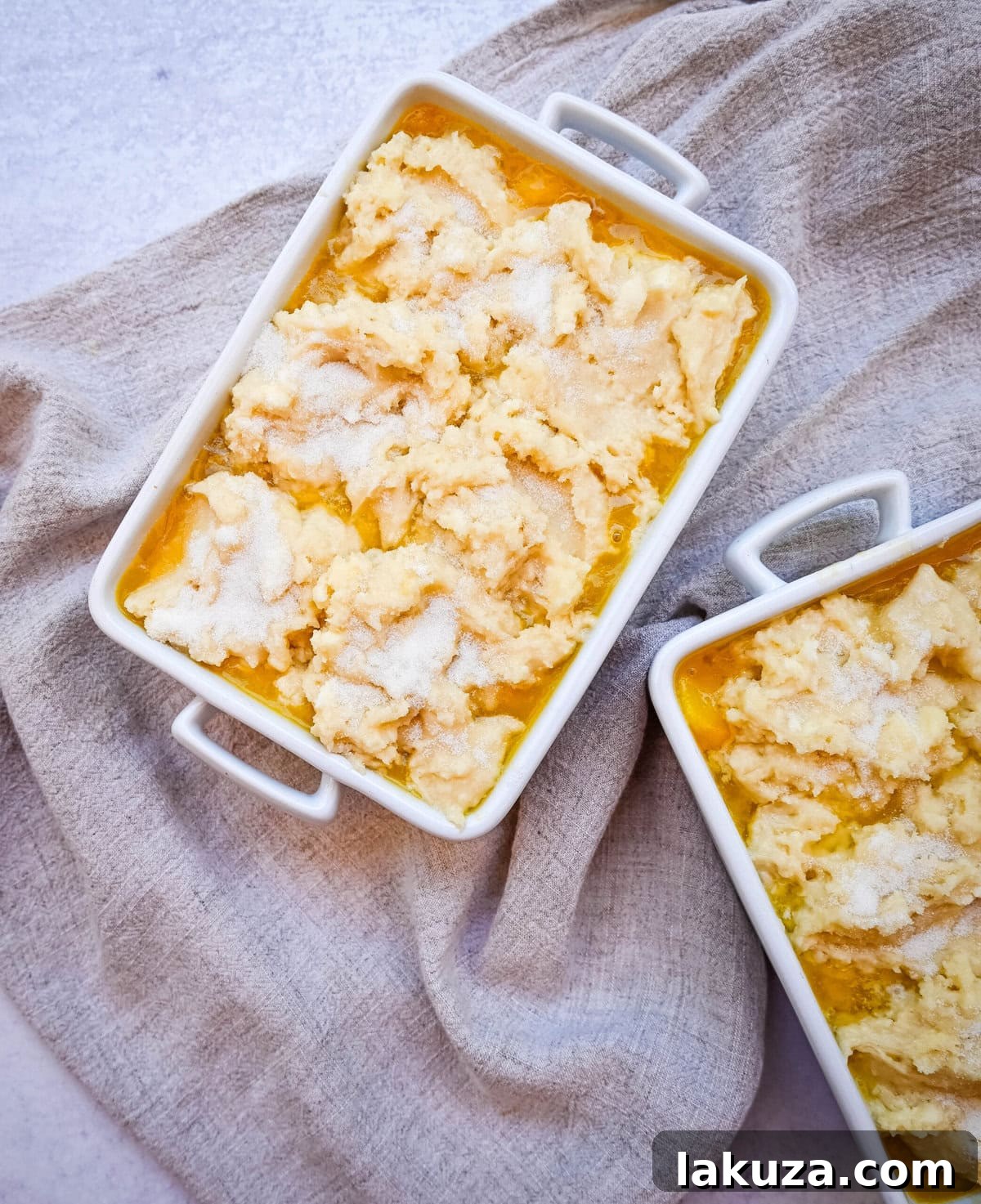 A step-by-step image of the homemade nectarine cobbler being assembled, showing the prepared fruit filling and the dropped biscuit topping, ready for baking.