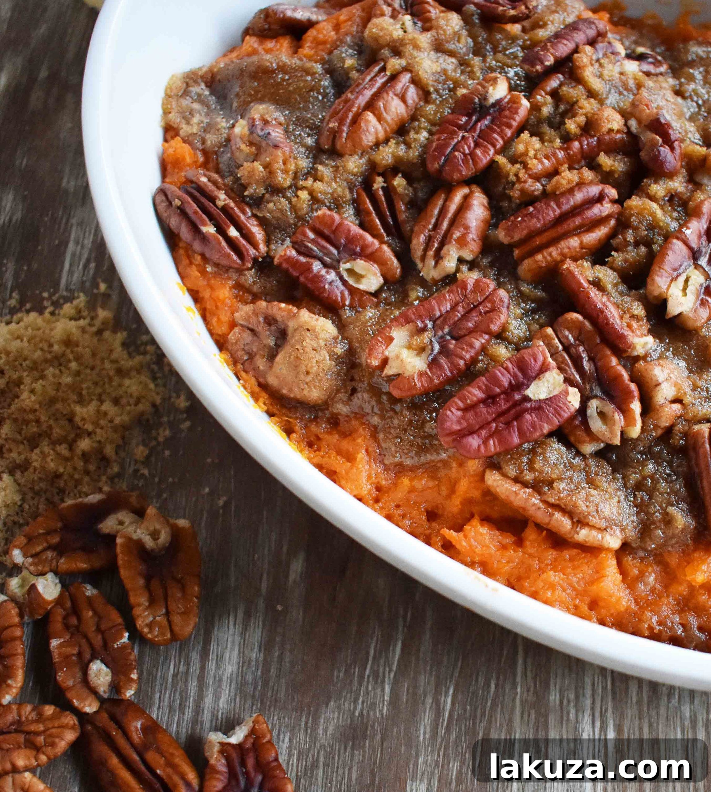 A close-up of Sweet Potato Brown Sugar Pecan Bake featuring its creamy texture and rich brown sugar pecan topping.