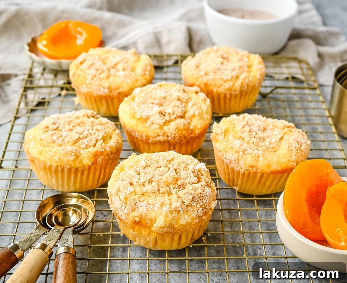 Close-up of freshly baked Peach Cobbler Muffins, showcasing their tender crumb, juicy peach pieces, and sweet streusel.