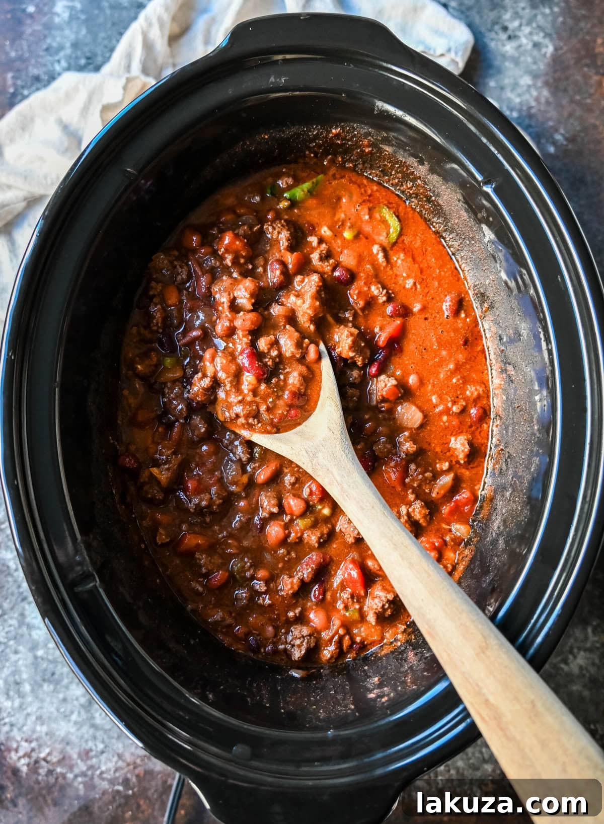 A vibrant aerial shot of crockpot beef chili, generously topped with an array of fresh ingredients.