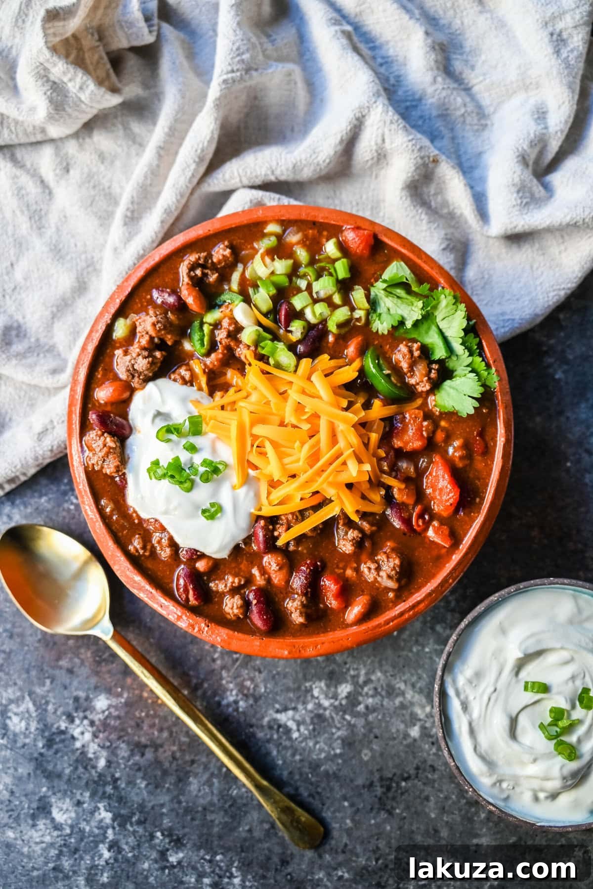 A close-up of slow cooker beef chili, featuring a rich, thick texture, waiting for toppings.