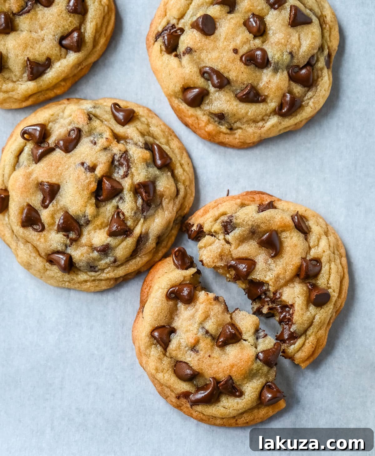 A close-up view of two types of chocolate chip cookies: one made with generic butter (more spread) and the other with premium European butter (less spread and richer color).