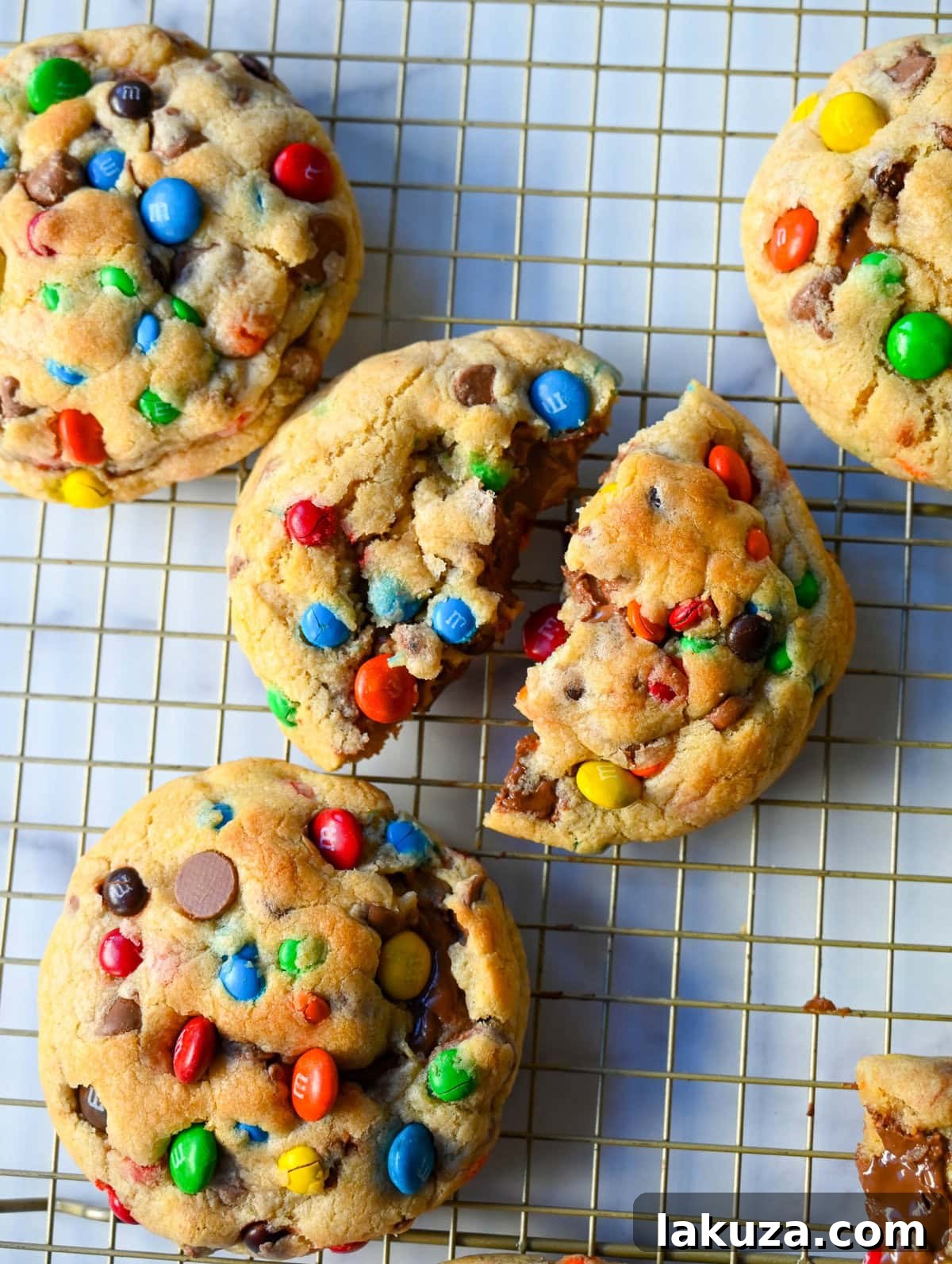 M&M Nutella Volcano Cookies 4 Three M&M Nutella Stuffed Cookies arranged on a cooling rack, showing their golden edges and colorful tops.