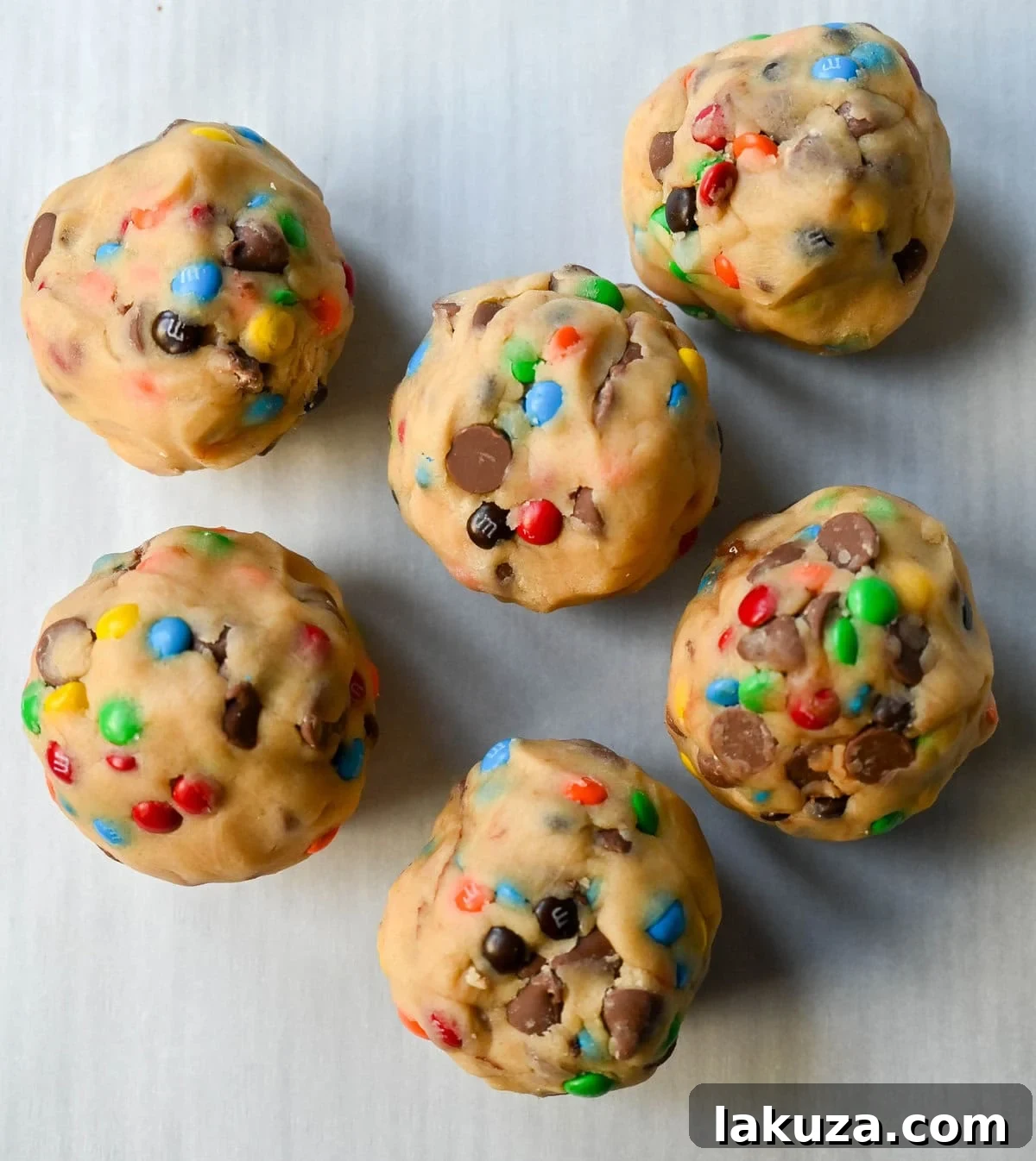 M&M Nutella Volcano Cookies 9 Six large M&M Nutella Lava Cookie dough balls on a baking sheet, ready for the oven.