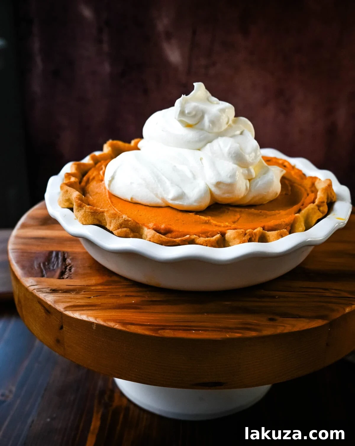 Golden Harvest Hillys Pumpkin Caramel Pie 11 The finished Milk Bar Pumpkin Caramel Pie, generously topped with whipped cream and streusel crumbs, ready to be served.