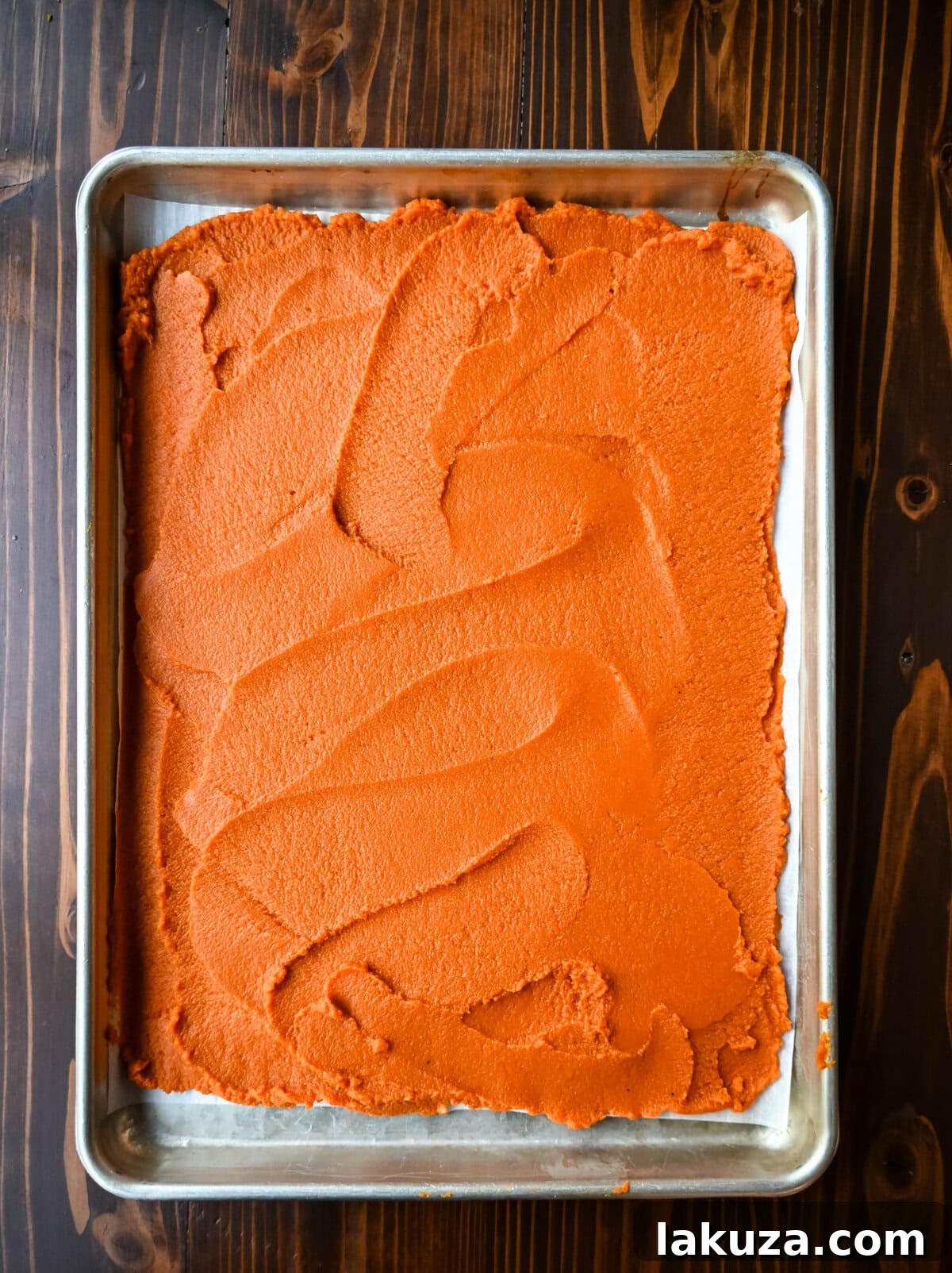 Golden Harvest Hillys Pumpkin Caramel Pie 6 Pumpkin puree spread on a parchment-lined baking sheet, roasting to remove moisture for the Milk Bar pumpkin pie.