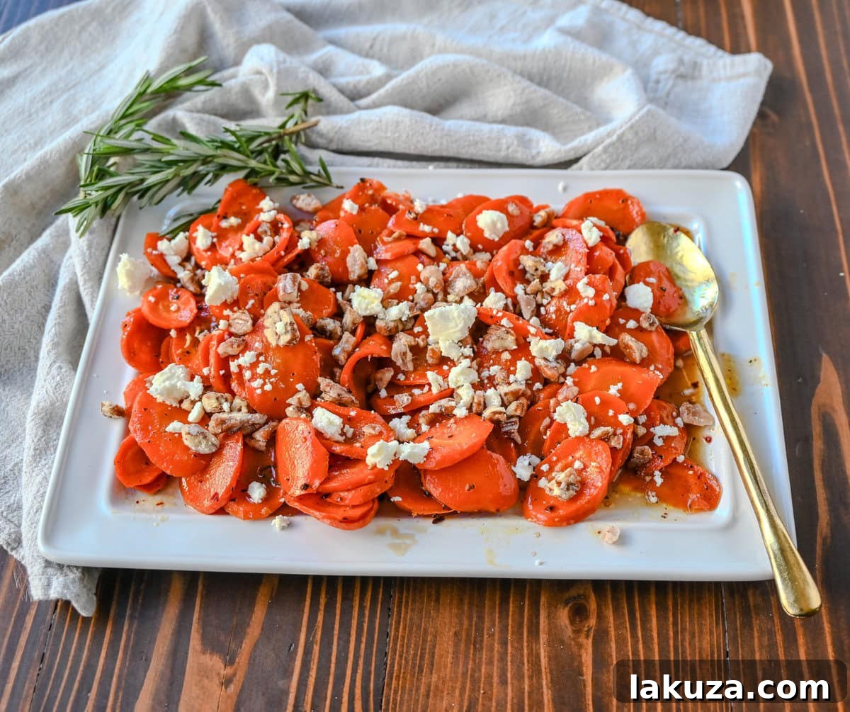 Close-up of Maple Glazed Carrots beautifully garnished with crumbled goat cheese and candied pecans, showcasing a perfect balance of sweet, savory, and tangy flavors.