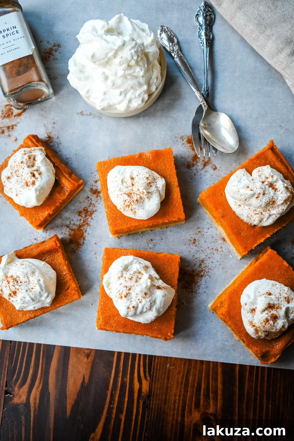 Close-up of a stack of golden brown pumpkin pie bars, showcasing the thick, creamy pumpkin filling and sturdy shortbread crust.