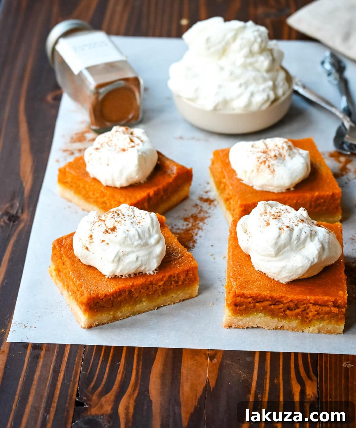 A baking pan filled with unbaked pumpkin pie bars, showing the creamy pumpkin filling spread evenly over the shortbread crust.