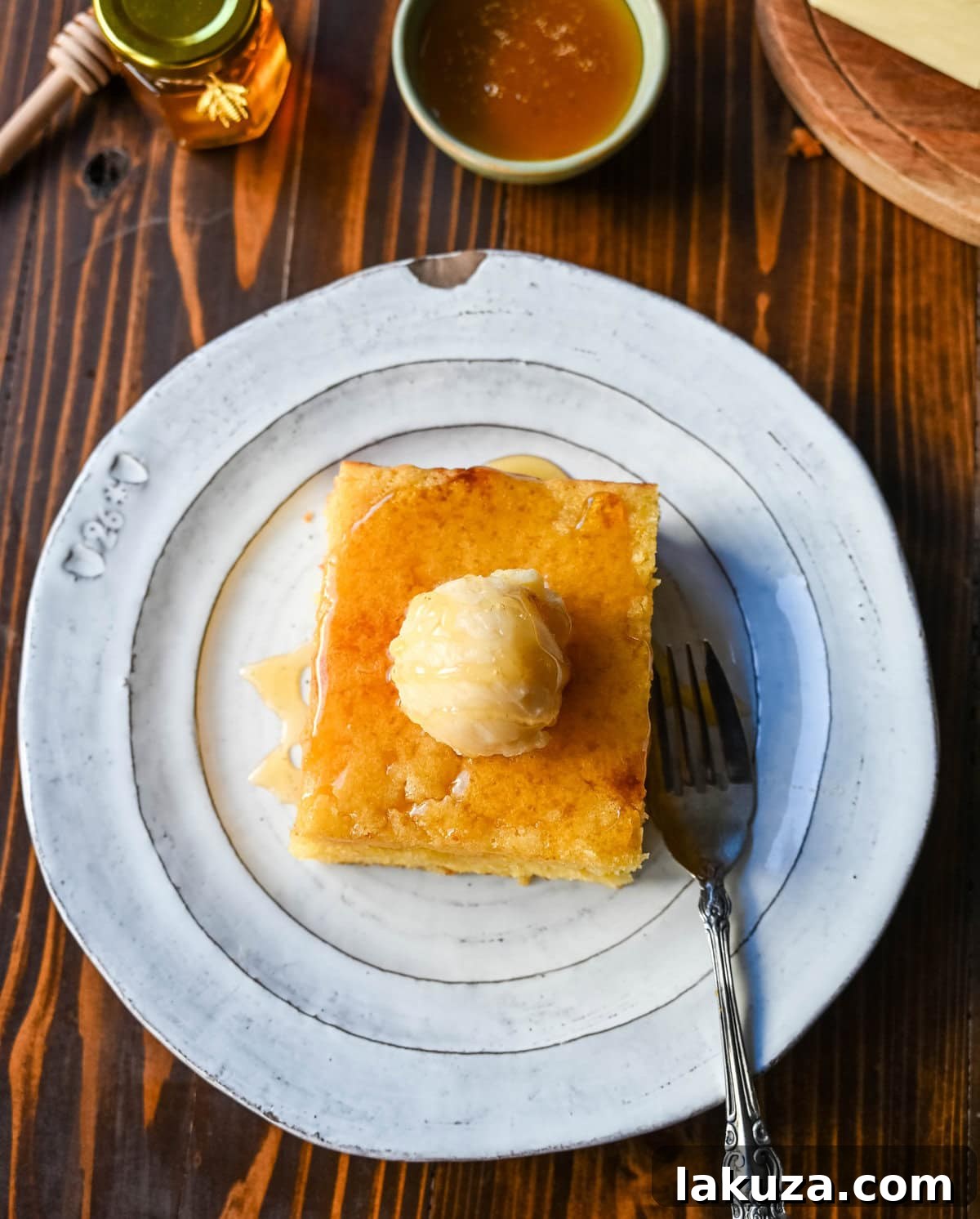 Southern Soul Cornbread 7 A freshly baked pan of moist cornbread with a slice cut out, ready to be enjoyed with honey butter.