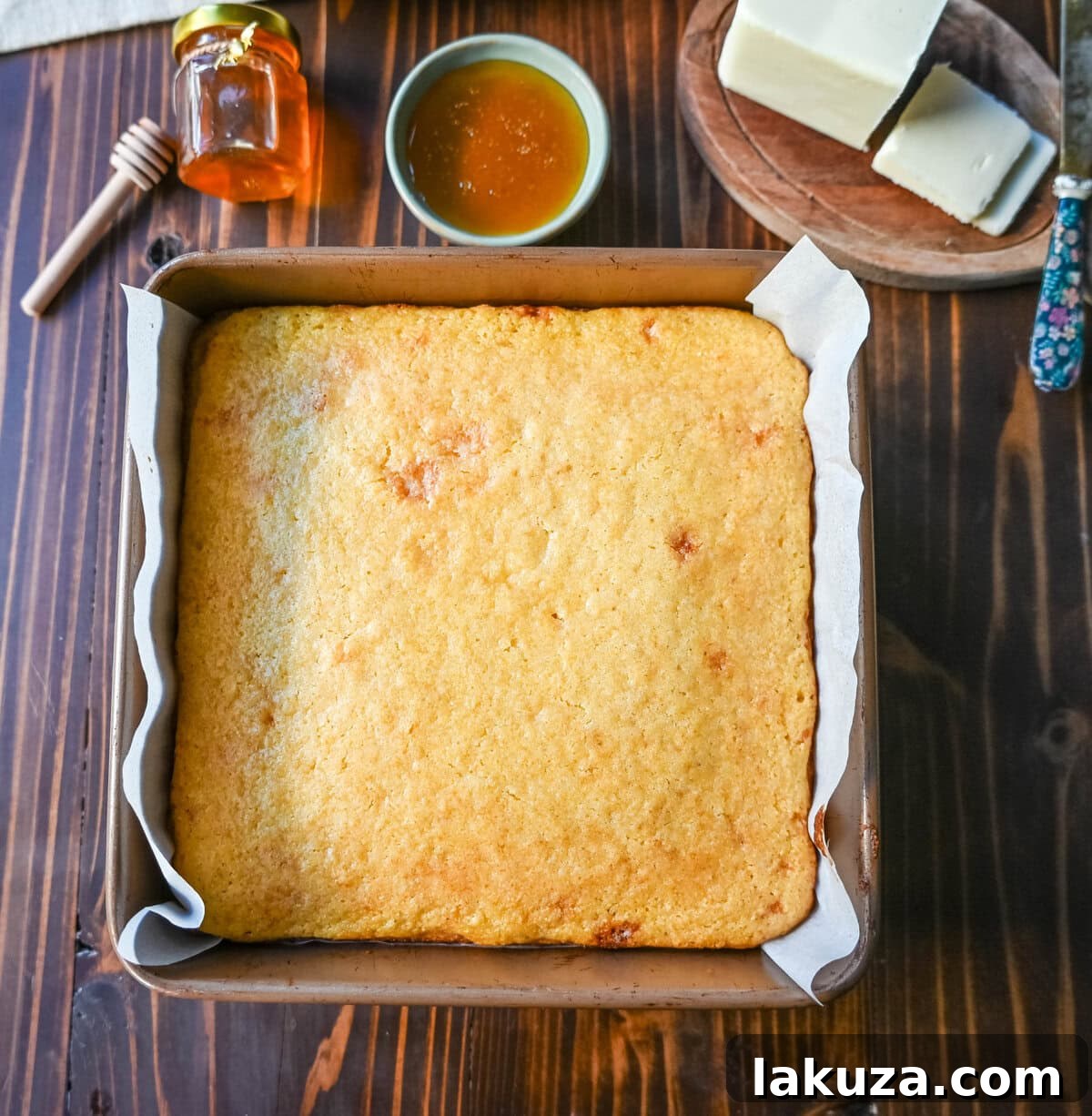 Southern Soul Cornbread 8 Illustrative image showing how to easily remove baked cornbread from a pan using parchment paper handles.
