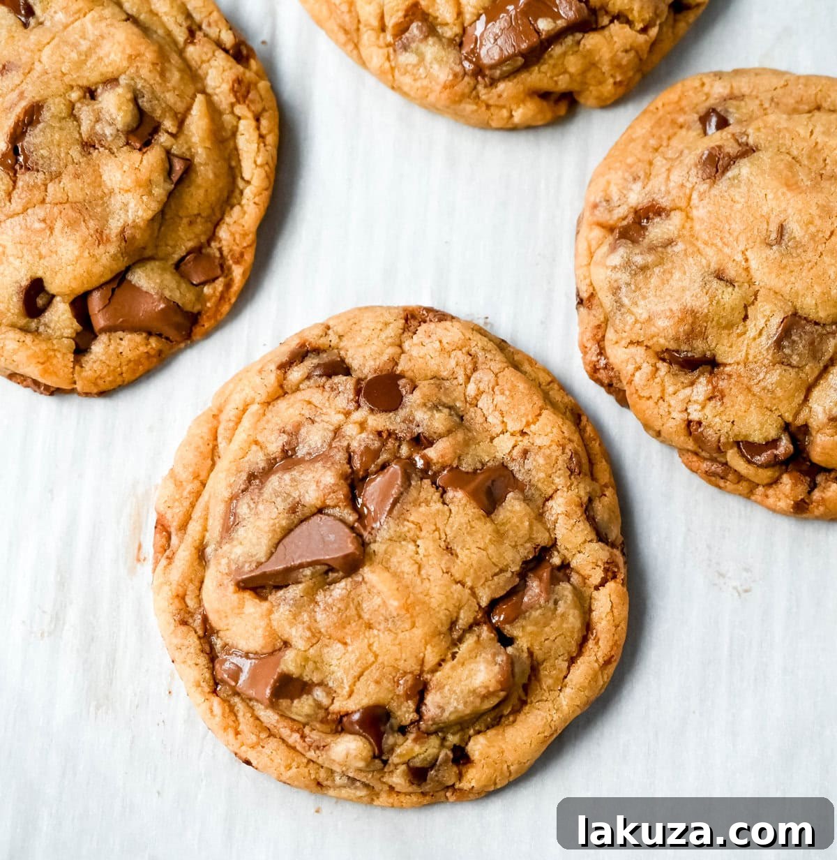 Irresistibly Chewy Condensed Milk Chocolate Chip Cookies 5 Ingredients for chewy chocolate chip cookies with sweetened condensed milk laid out, including melted butter, brown sugar, and chocolate chunks.